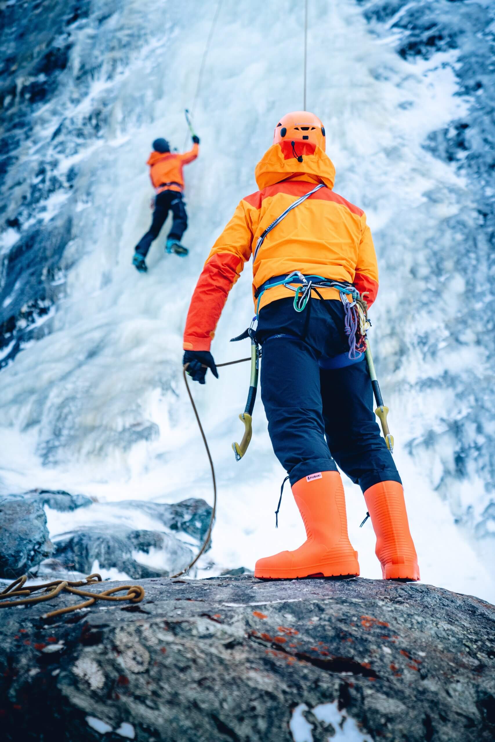 two people climbing frozen waterfall