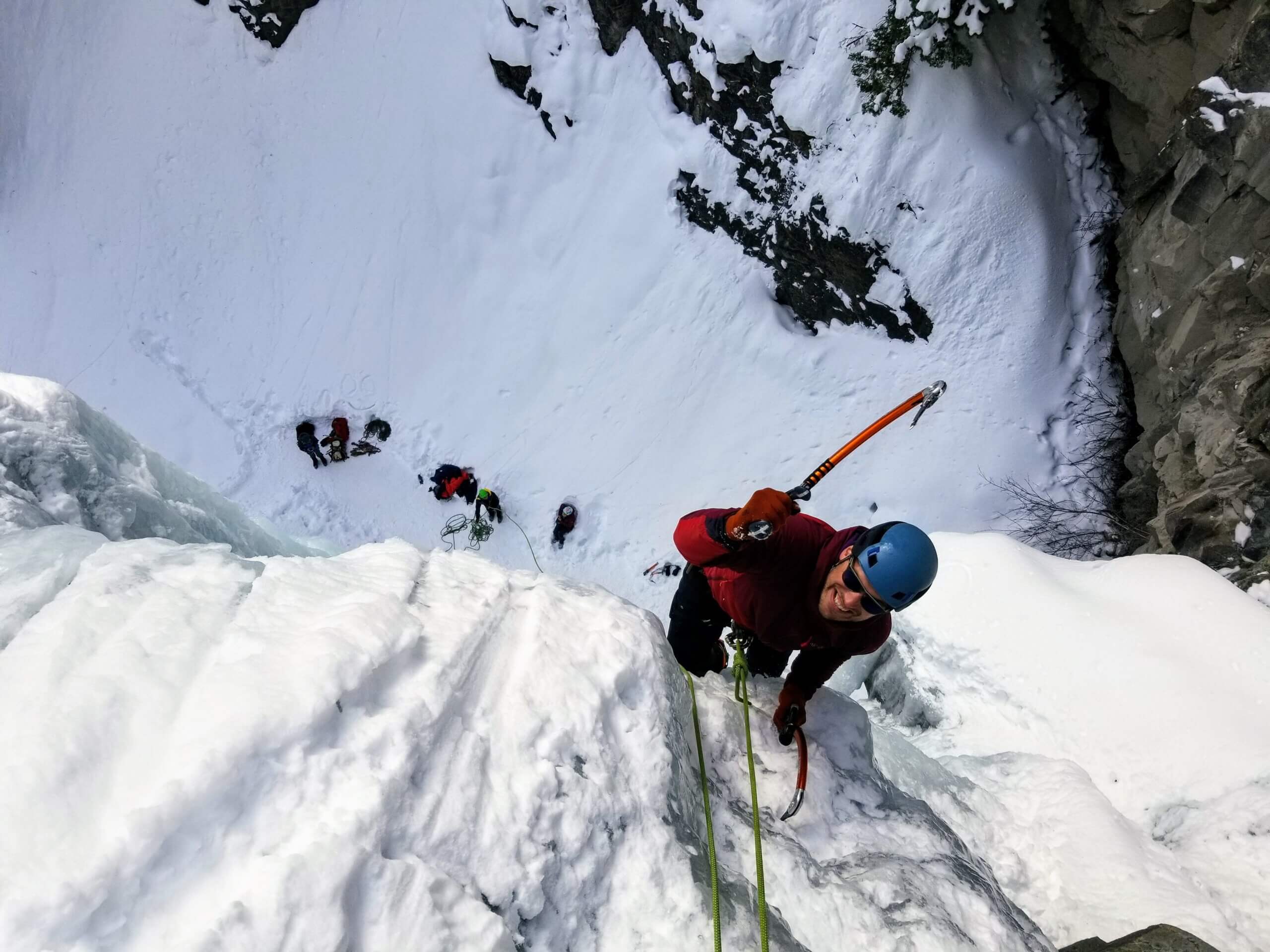 man ice climbing with ice pick