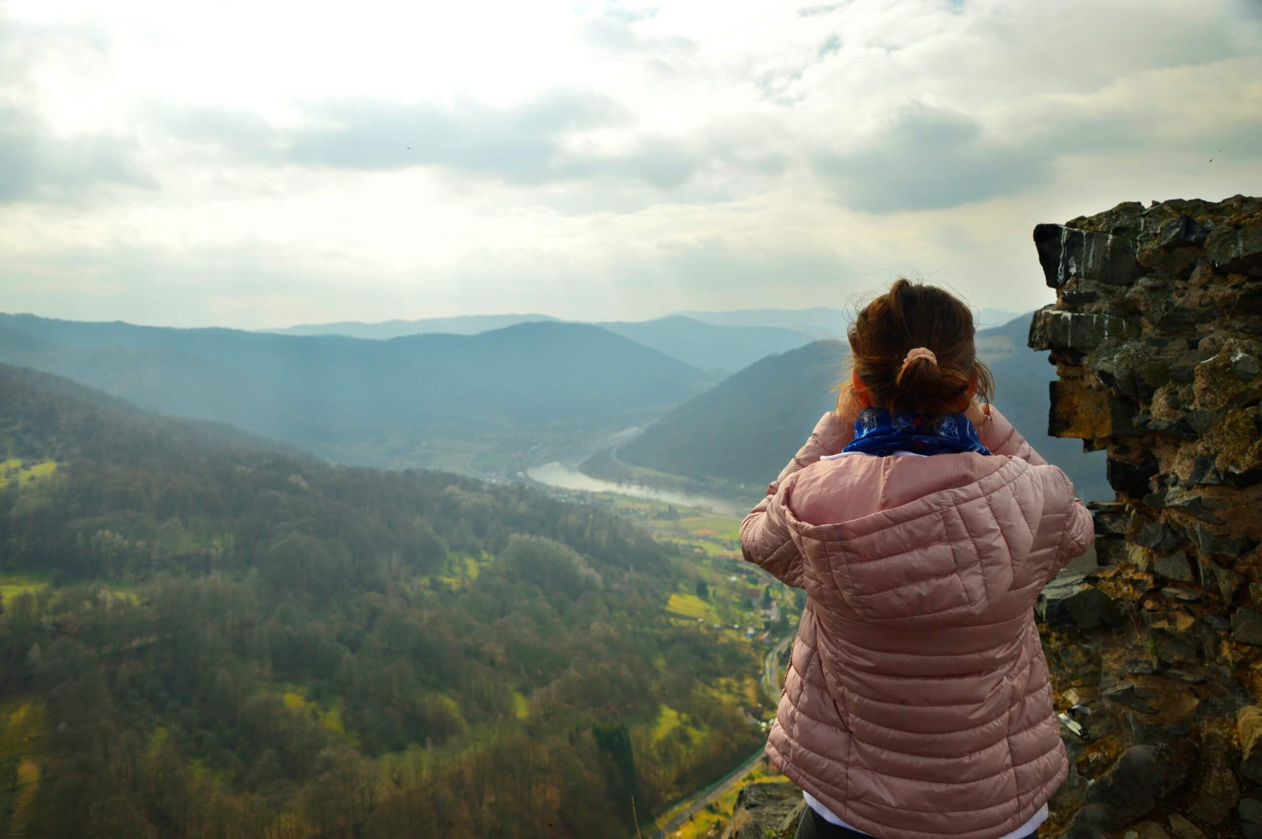 girl looking over valley with binoculars
